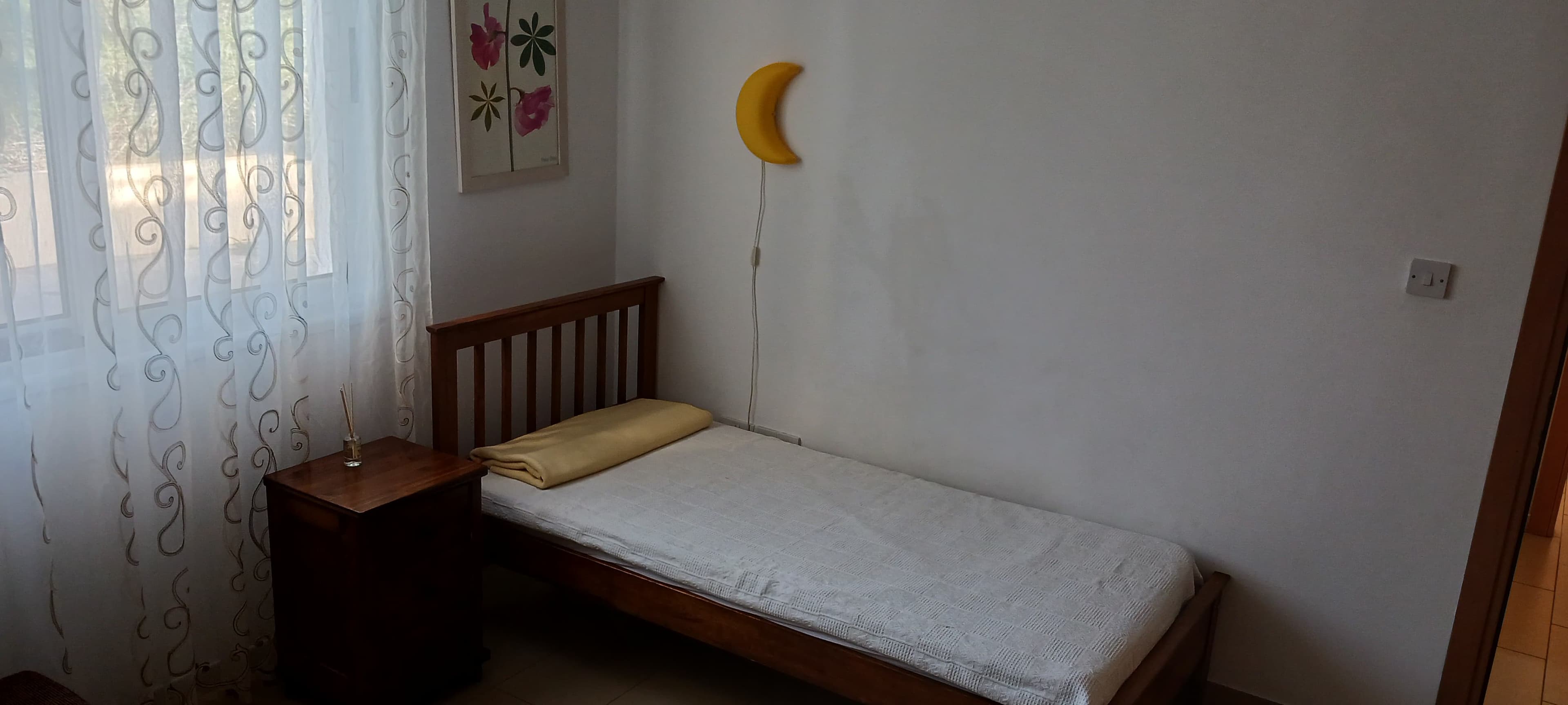Second bedroom with a single bed, bedside table and bright window